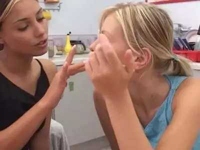 Mit einem Dildo bumsen sich die Lesbierinnen mit den kleinen Brüsten